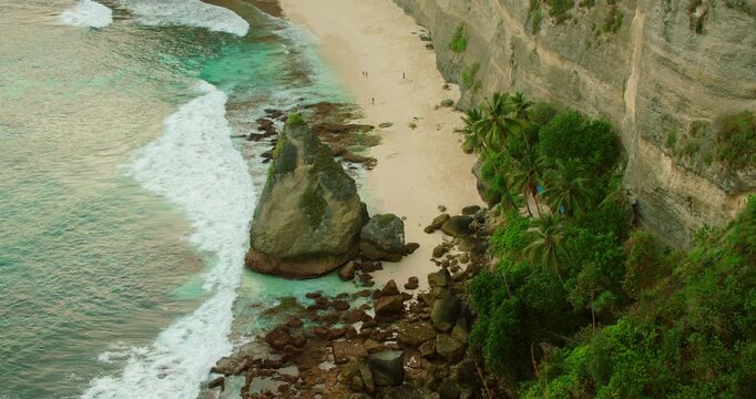 Beautiful view of secluded tropical bay with turquoise ocean and white sand beach in Indonesia