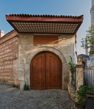 The historic side entrance of the Carpet Museum, Hali Muzesi, located in Istanbul, Turkey, featuring a large wooden arched door and traditional Ottoman architecture on a sunny day
