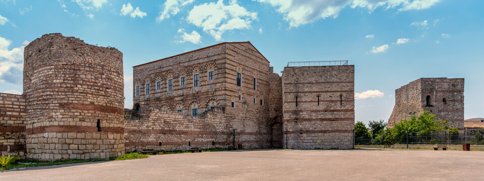 Exterior view of the historic Palace of the Porphyrogenitus, aka Tekfur Sarayi, Istanbul, Turkey, showcasing preserved Byzantine stone and brick facade and ancient defensive walls under clear blue sky