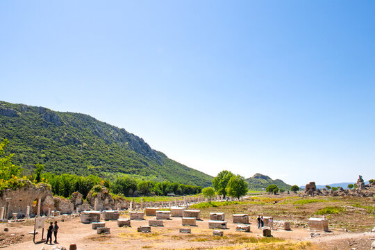The ancient city of Ephesus. Sarcophagi and visitors at the ancient city of Ephesus (Efes). Open air museum concept. A historical tourist destination in T&uuml;rkiye. Copy space, blank, empty. 