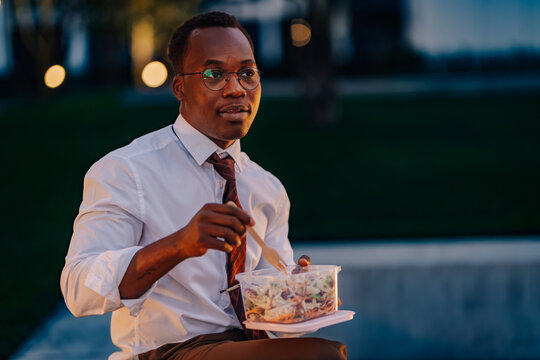 Black businessman enjoying healthy salad lunch outdoors