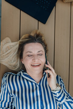 Woman laughing while speaking on smartphone online