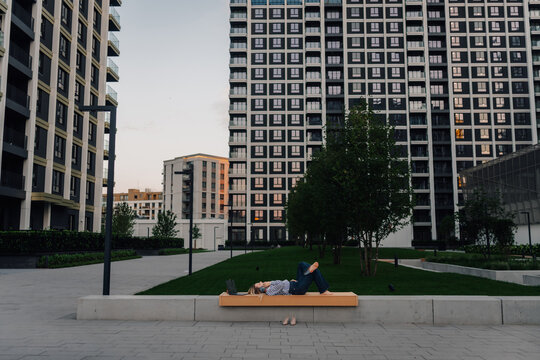 Young woman relaxing on bench in modern urban park