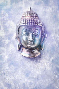 Buddha head on rustic wooden background. Soft focus. Top view. Copy space.