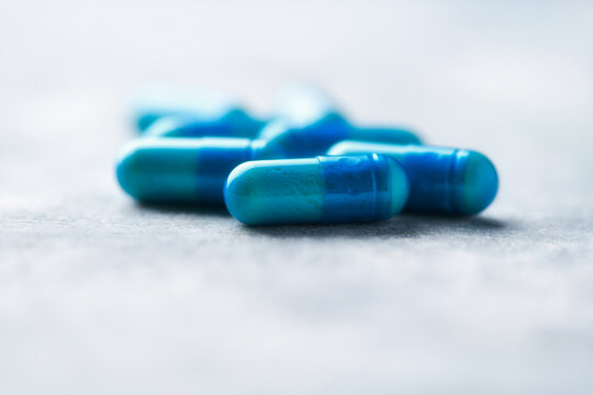 Amino acids capsules on wooden background. Soft focus. Close up