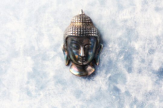 Buddha head on rustic wooden background. Soft focus. Top view. Copy space.