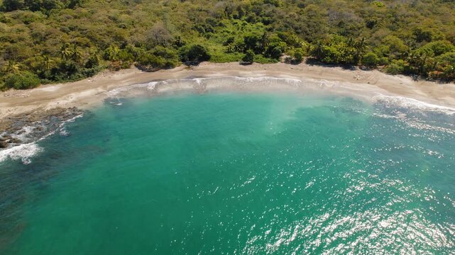 Tropical bay with turquoise ocean water and forest at Pitahaya beach Costa Rica
