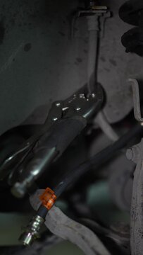 Locking pliers clamp an old brake hose near new line.
