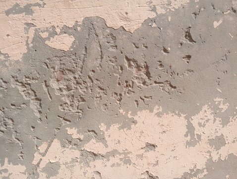 Grunge concrete wall texture background. Peeling paint on old cement structure showing damaged plaster layers. Rough weathered surface pattern for industrial graphic design and rustic 3D rendering.