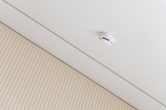 Smoke detector mounted on a white ceiling