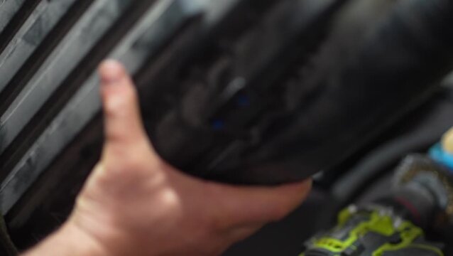 Mechanic closes the plastic lid of the car airbox housing.