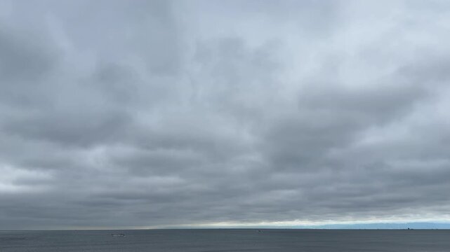 雲の切れ間に光が差す空と穏やかな水平線