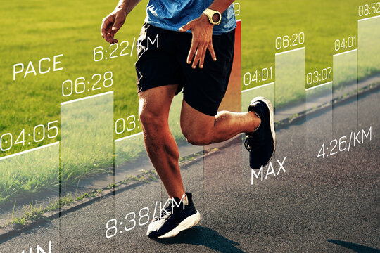 Runner tracks performance data while jogging on a track field in the afternoon