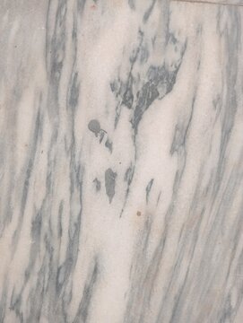 White marble texture background with gray veins. Natural polished stone surface showing abstract organic patterns. Elegant mineral material for luxury interior design, flooring, and kitchen