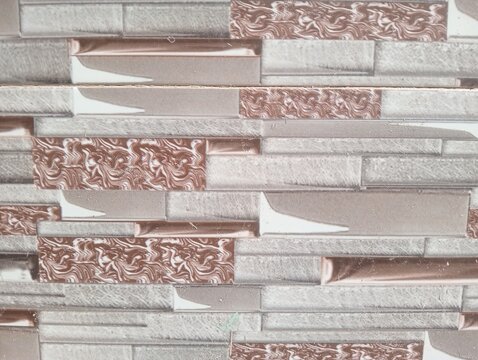 Stone cladding wall texture background. Modern decorative wall tiles with grey slate and brown marble patterned inserts. Seamless natural stone block pattern for interior and exterior design.