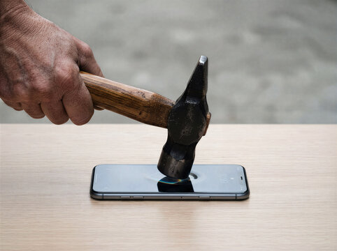 Hammer hitting smartphone screen, durability stress test of mobile phone, man smashing cell phone with hammer