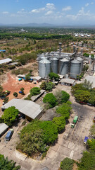 Industrial grain storage silos surrounded by trees and trucks in South Kalimantan Indonesia © Salsabila Ariadina