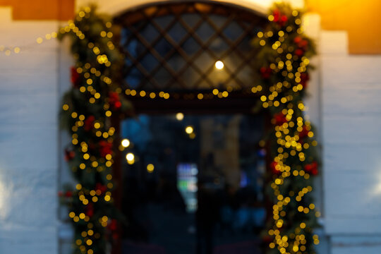 Blurred Christmas entrance with glowing golden fairy lights and festive holiday garland decor