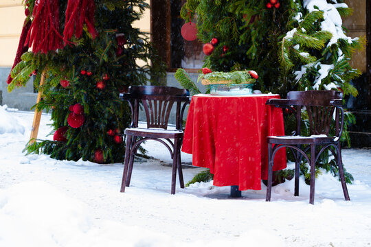 funny decorative dinner place outside on a street in winter snow wall time Christmas eve season with festive interior and exterior objects