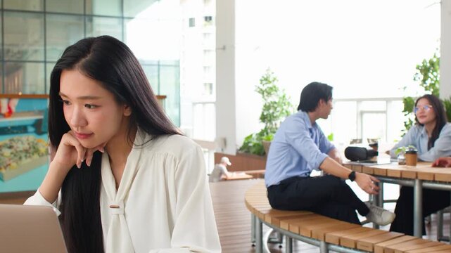 Asian Businesswoman Working on Laptop in Modern Office Cafeteria