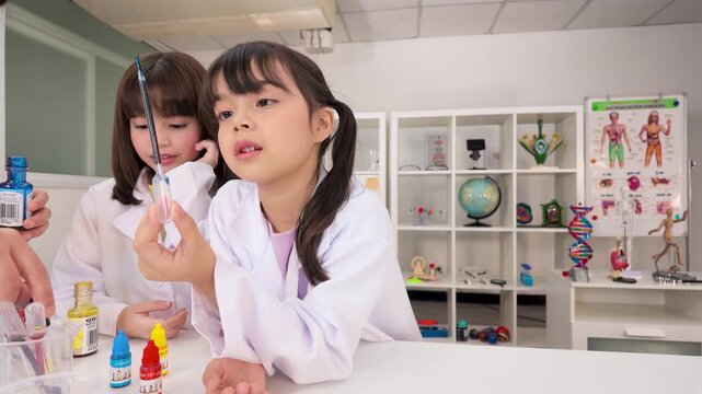 Young Girls in Lab Coats Conducting Science Experiments in Classroom
