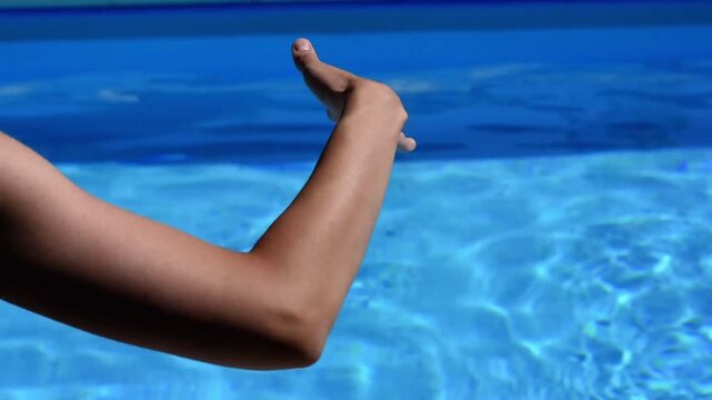 Woman's hand waving in smooth flowing dance move by the pool short HD video