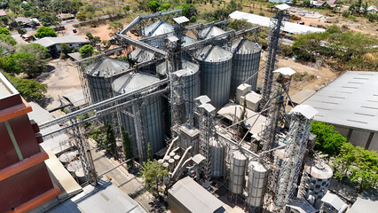 Large metal silos for grain storage at an industrial processing plant viewed from above © Salsabila Ariadina