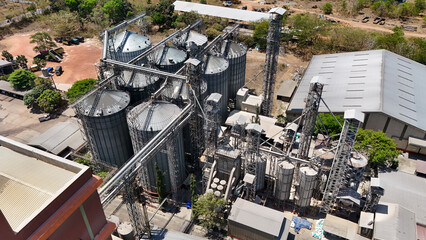 Grain storage facility with tall metal silos and processing equipment in an industrial setting © Salsabila Ariadina