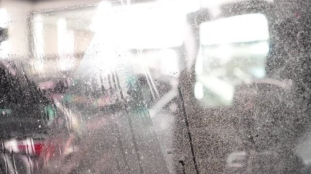 Master installs a protective transparent polyurethane film on a car windshield, before application copiously wetting it with a soapy mixture. Clear wrap protects glass from stone chips, scratches, UV.