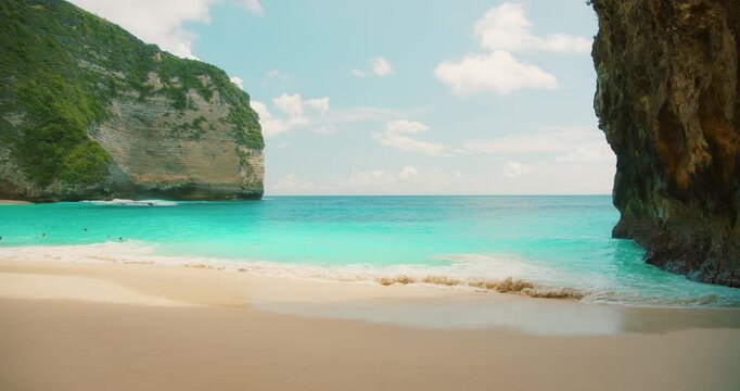 Peaceful tropical view with ocean waves and high rocky cliffs at Kelingking Beach Bali Nusa Penida