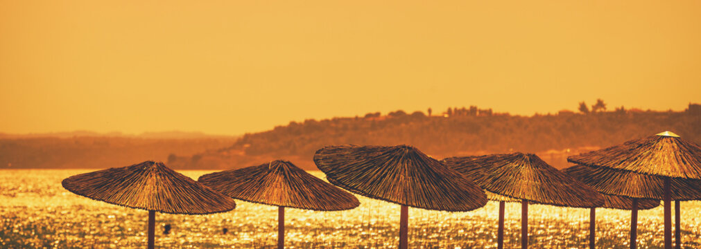 Seascape with straw sun umbrellas on the beach
