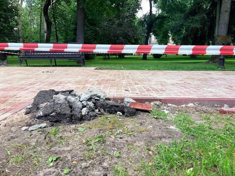 Repair work in the city. a pile of excavated dark soil, rocks on the ground next to a newly laid brick pathway.
