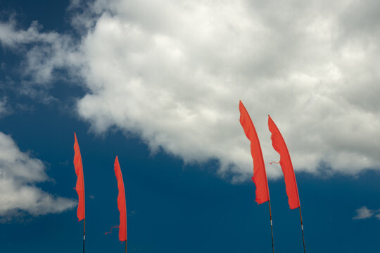 Vivid orange flags against deep blue sky on sunny day.Complementary colours concept.