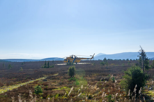 Helicopter in the field of tundra in the mountains.