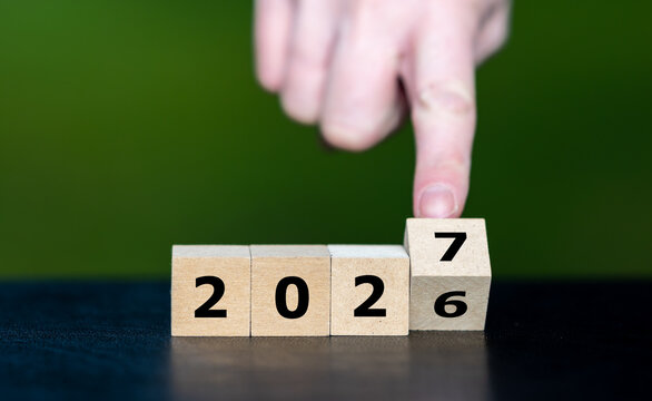Hand turns year cubes from 2026 to 2027 for a new beginning