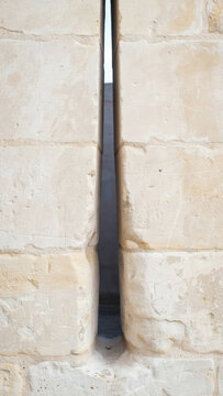 Ancient stone arrow slit fortification wall detail showing traditional medieval defensive architectural defensive design
