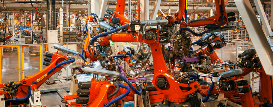 Automated robotic arms working in a modern automobile manufacturing plant.