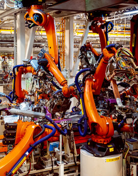 Automated robotic arms working in a modern automobile manufacturing plant.