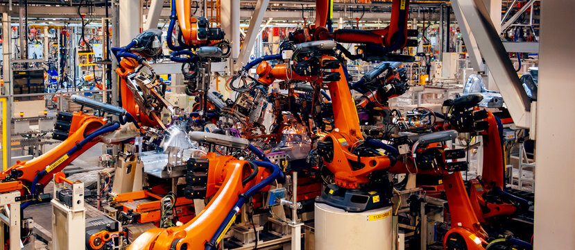 Automated robotic arms working in a modern automobile manufacturing plant.
