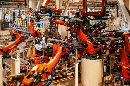 Automated robotic arms working in a modern automobile manufacturing plant.
