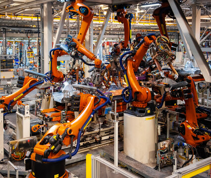 Automated robotic arms working in a modern automobile manufacturing plant.