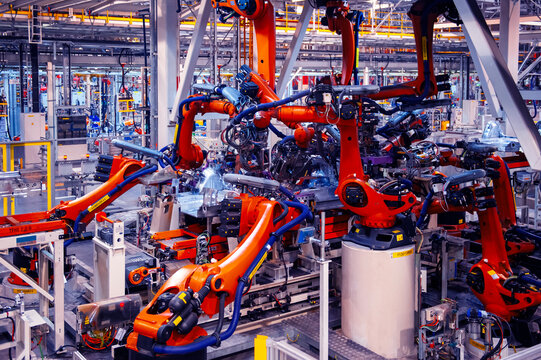 Automated robotic arms working in a modern automobile manufacturing plant.