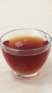 Pouring White Sugar into Clear Glass Cup of Hot Black Tea