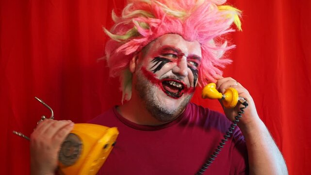 A man clown putting on a red nose - sitting in front of the mirror and smile