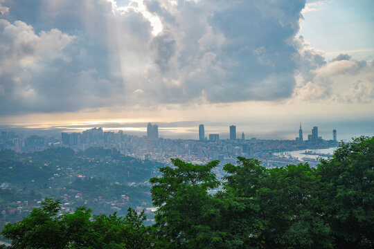 Panoramic view of Batumi city skyline with dramatic sunbeams through clouds with copy space