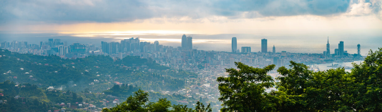 Wide panorama of Batumi city skyline and Black Sea under dramatic clouds with copy space