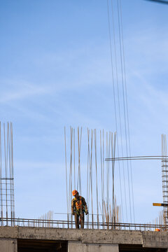 American construction worker stands under wide sky with copy space