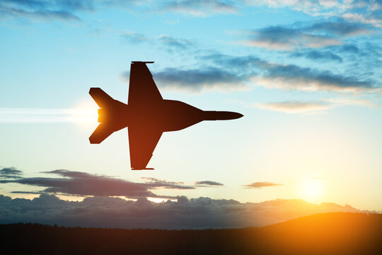 Air Force Day. Aircraft silhouette on background of sunset. Combat flight of interceptor on a mission.