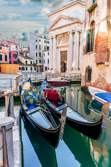 gondolas in venetian canal decorated in traditional vintage style of Venice and old architecture buildings on background © Yaroslav