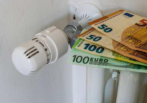euro bankonotes on radiator. heating price increase. money consumption for heat. expensive winter season. european civil energetic